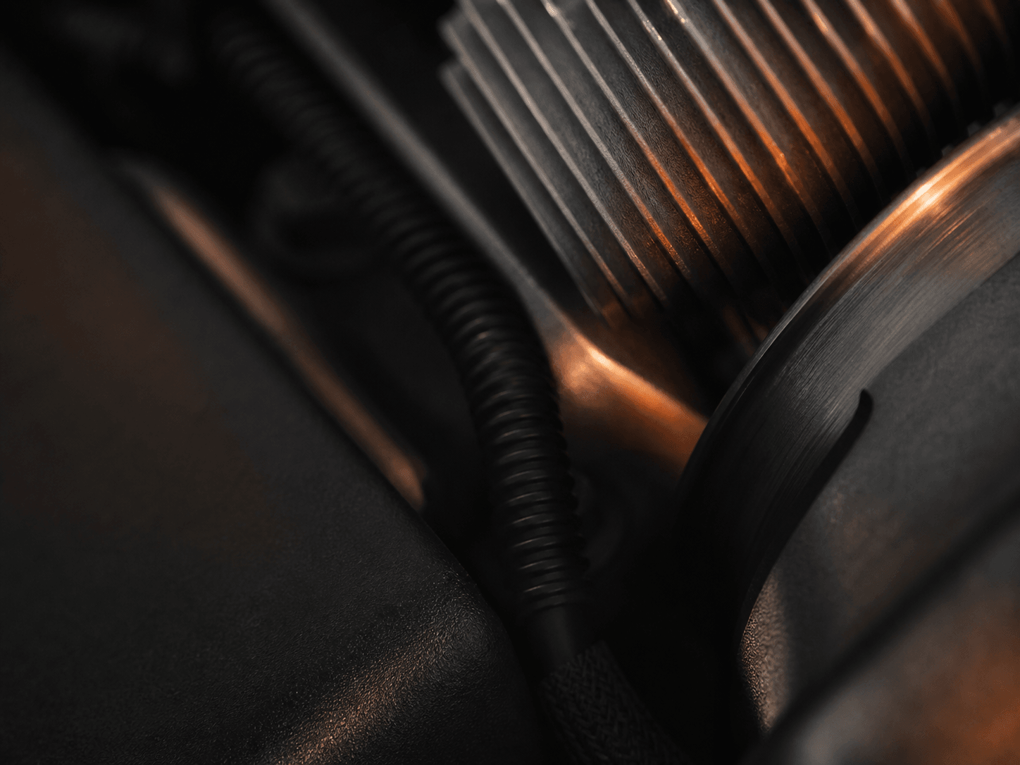 Abstract close-up of dark mechanical surfaces in warm workshop light