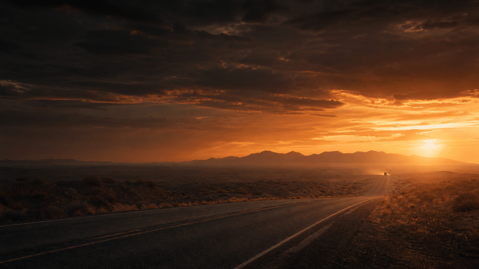 Desert highway crossing a rugged landscape at sunset